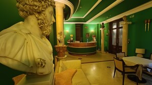 A lobby with a reception desk, a bust sculpture, a roundabout, and a seating area. - Hotel Seccy Boutique Art & Museum (Fiumicino)