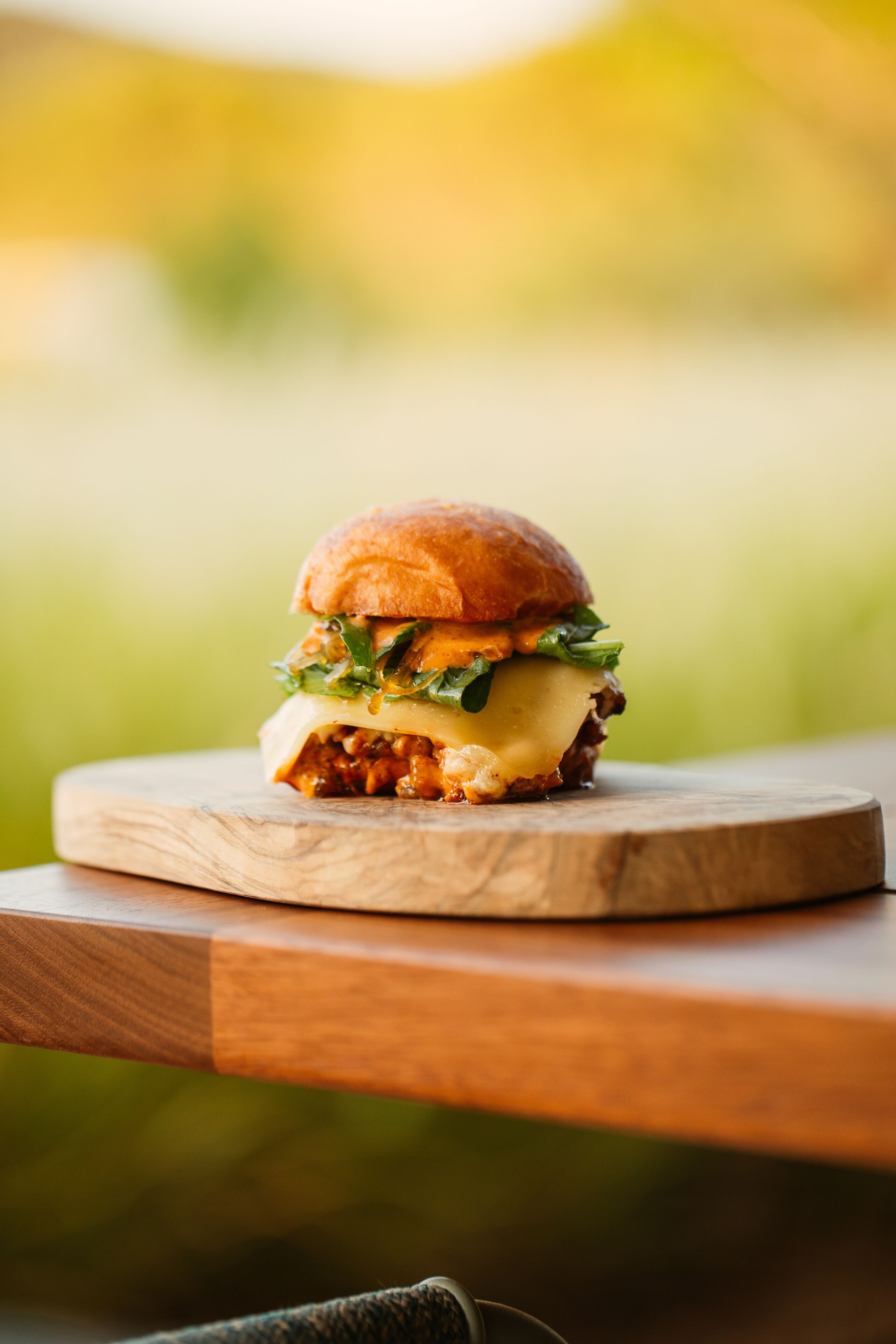 Una hamburguesa sobre una tabla de madera.