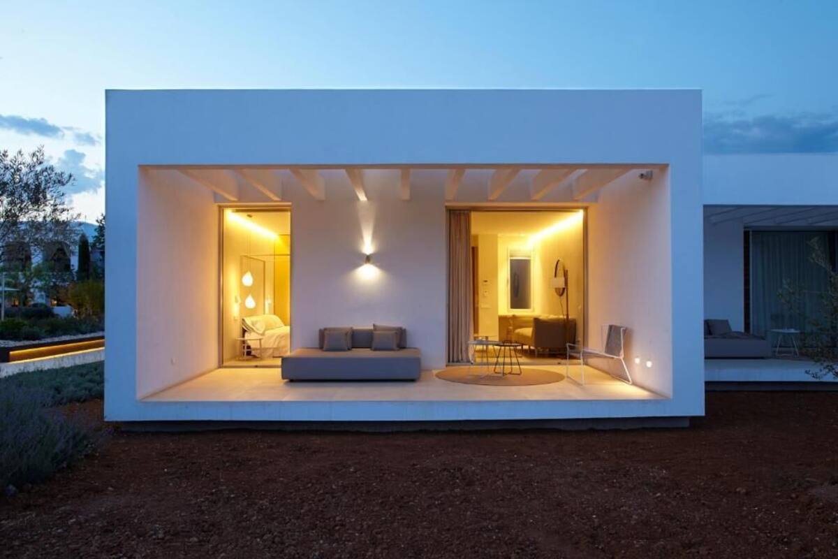 Een modern, minimalistisch huis met een open leefruimte, een eethoek en een zichtbare keuken.