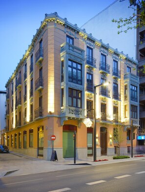 A multi-story building with ornate architectural details, including decorative balconies and a green shuttered entrance. - Suites Gran Via 44 Apartahotel (Granada)