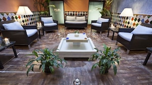 A lounge area with wicker furniture, a central coffee table, and potted plants.