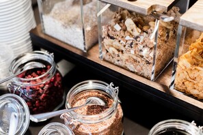 A variety of food items in glass containers, including granola, cereal, and a layered dessert.
