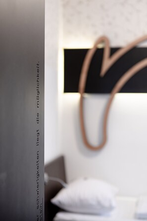A close-up of a wall with a heart-shaped light fixture and a partially visible text.