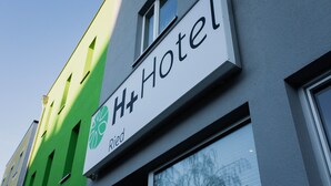 A hotel sign with a green and white color scheme, featuring the logo and name "H+Hotel". - H+ Hotel Ried (Ried im Innkreis)