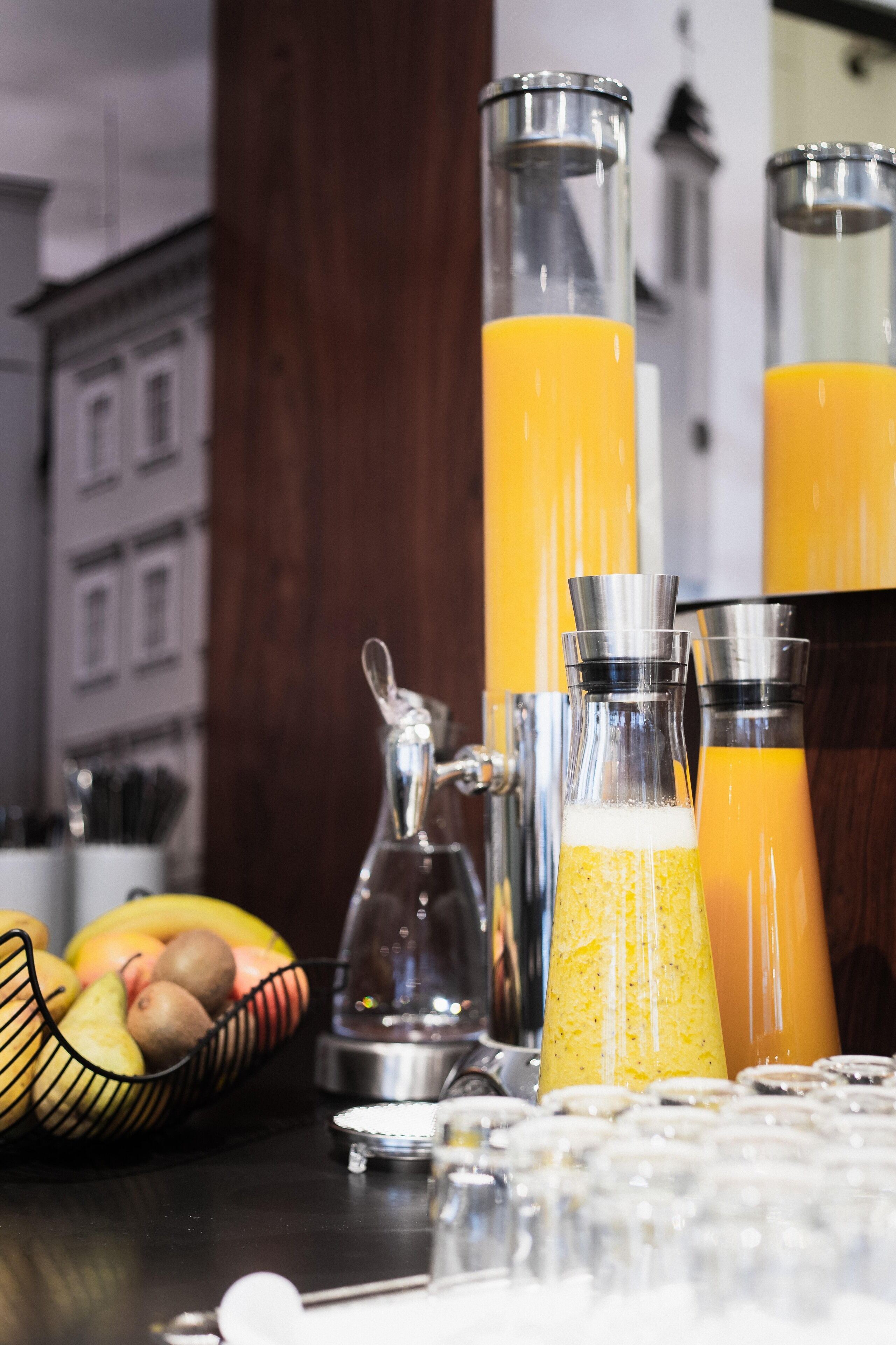 Eine Küchenarbeitsplatte mit verschiedenen Glaskolben, einem Obstkorb und einer Kaffeemaschine.