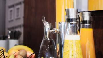 Una encimera de cocina con varios recipientes de vidrio, una cesta de fruta y una cafetera.