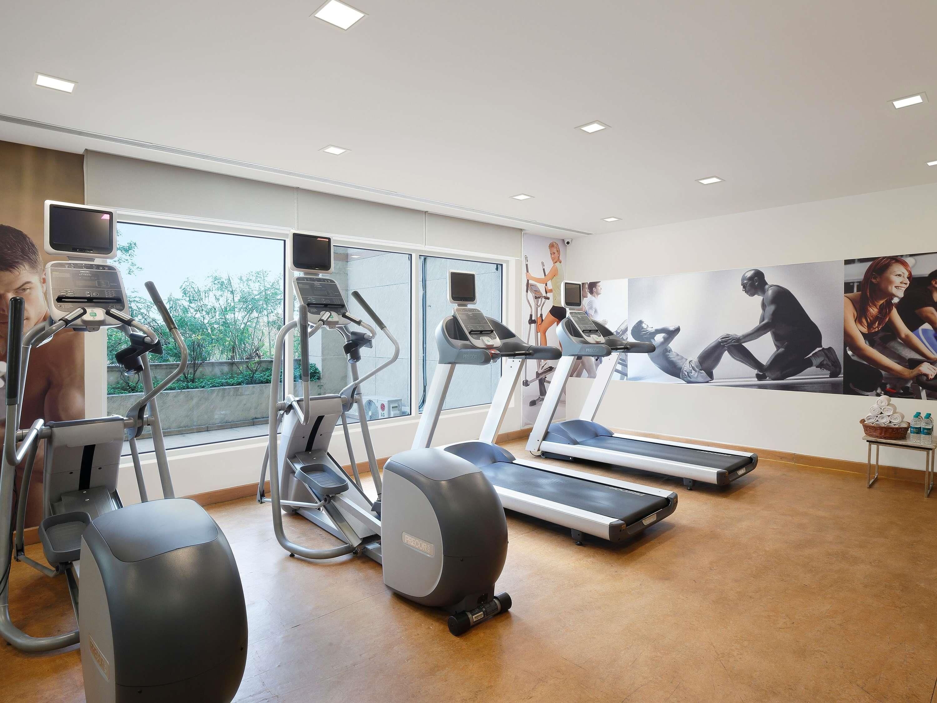 A gym with treadmills, elliptical machines, and stationary bikes.