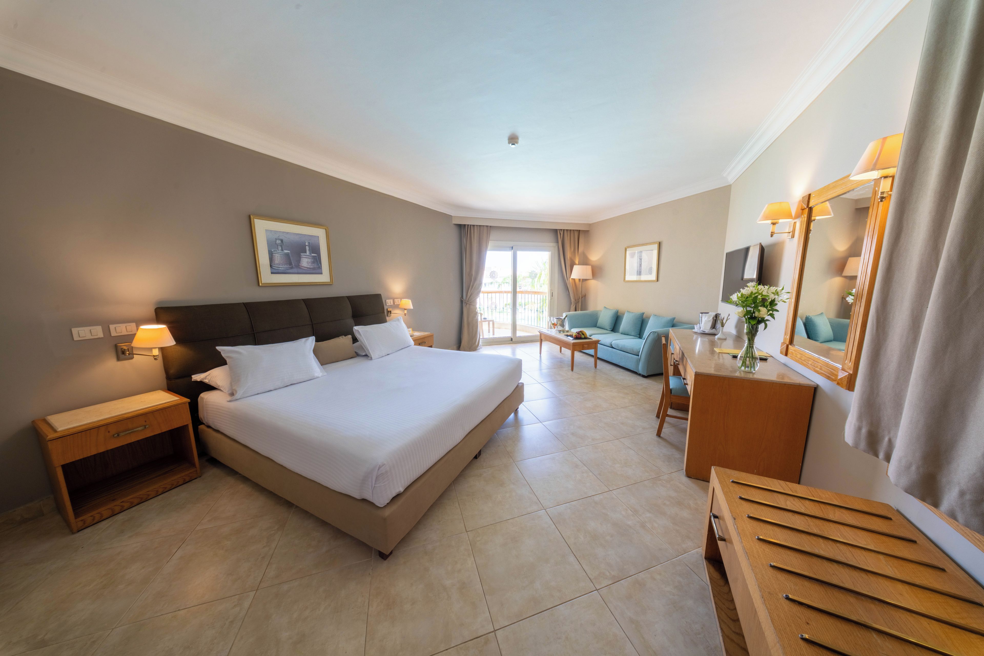 Une chambre d’hôtel avec un grand lit, un canapé, un bureau et un miroir.