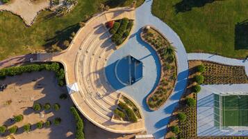Vista aérea de una zona ajardinada con una estructura circular central, rodeada de senderos y vegetación.