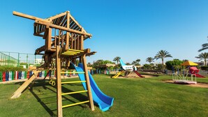 A playground with a wooden climbing structure, slides, and a fenced area. - Aurora Oriental Resort Sharm El Sheikh (Sharm El Sheikh)