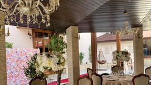 An indoor dining area with round tables, chairs, and chandeliers. - Hotel Impero (Oradea)