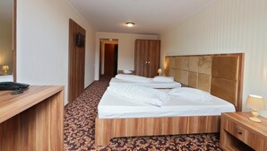 A hotel room with a bed, bedside tables, a desk, a telephone, and a mirror. - Hotel Impero (Oradea)