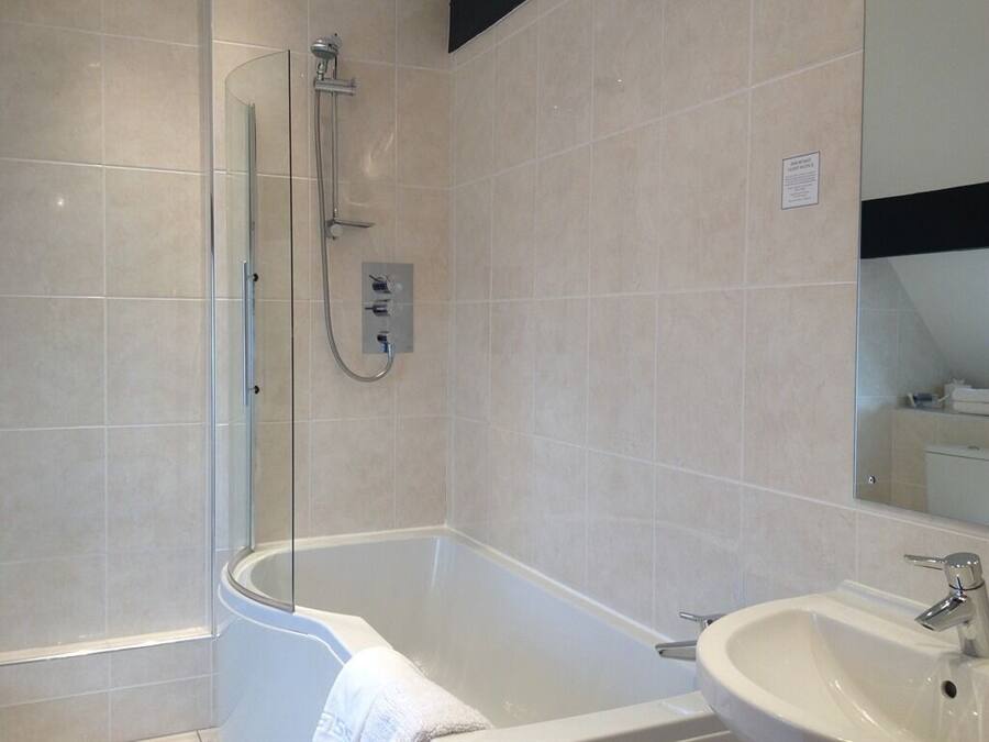 Un baño moderno con ducha de vidrio, bañera independiente y lavamanos.