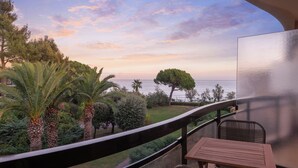 Un balcón con vistas al mar, amueblado con una mesa y sillas.