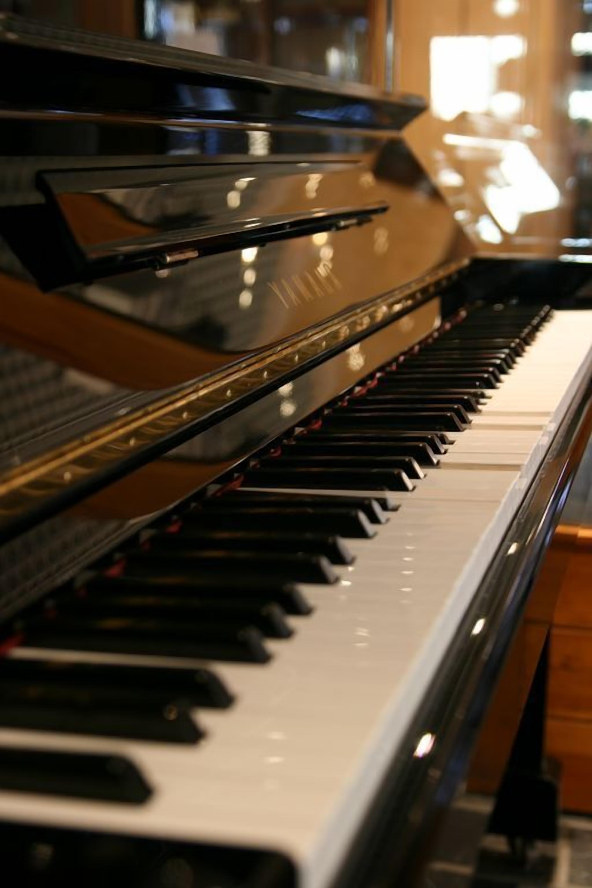 Un piano à queue doté d’une finition noire brillante et d’une surface réfléchissante.