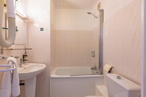 Een badkamer met een wastafel, een badkuip en een toilet.