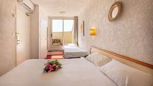 Ein Hotelzimmer mit einem Bett, einem kleinen Tisch und Blick ins Freie.