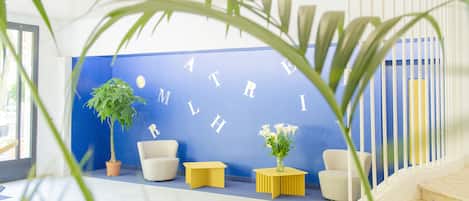 A reception area with a blue wall, white furniture, and a staircase.