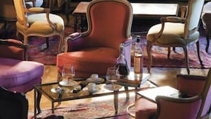 A cozy room with a wooden bench, plush armchairs, and a coffee table. - L'Esplanade (Domme)