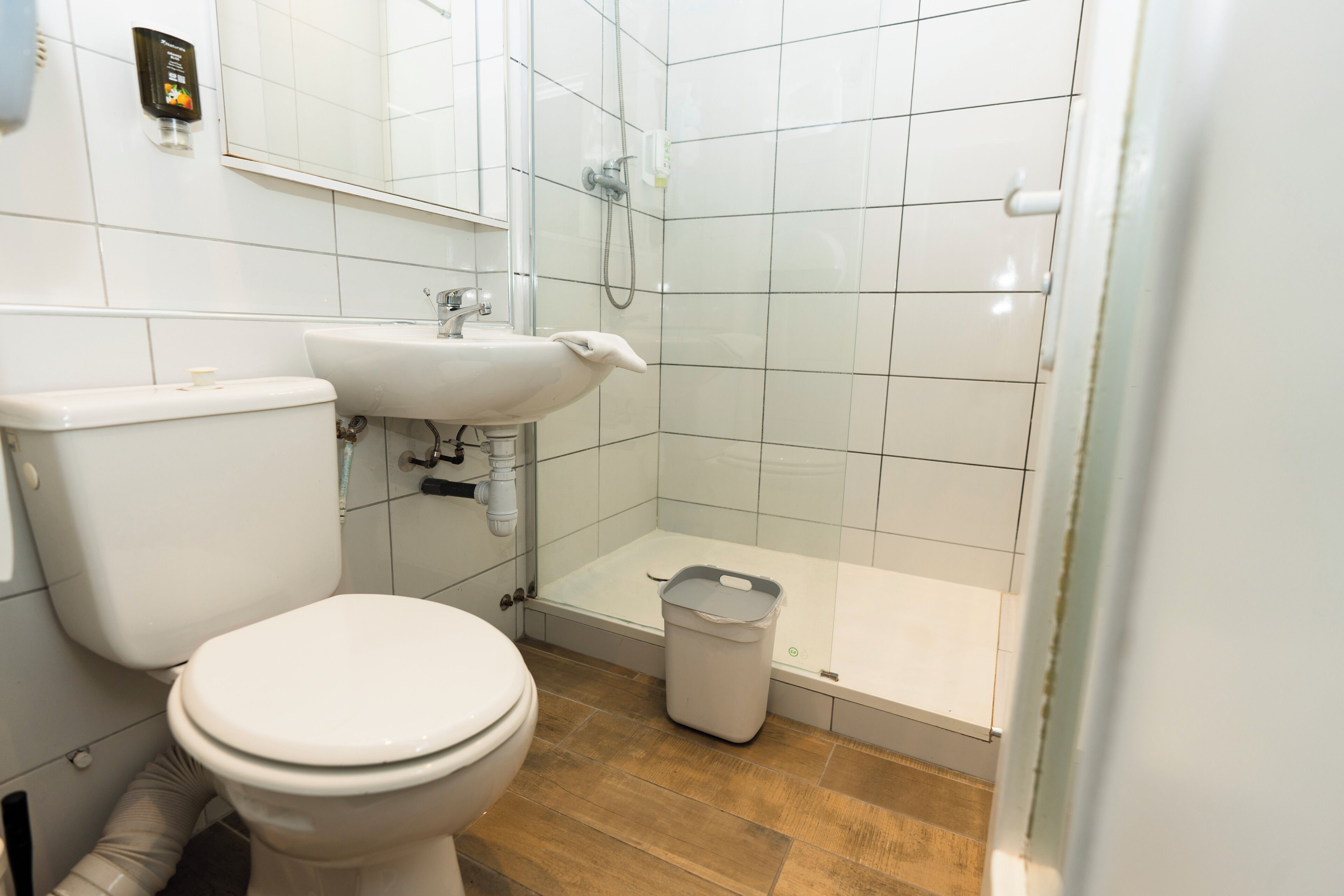 A bathroom with a toilet, sink, and shower.