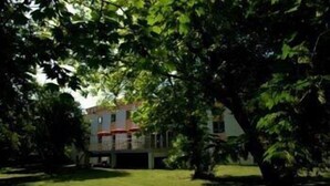 A two-story house with a covered patio and a lawn in front. - Citotel les Alizes (Eysines)