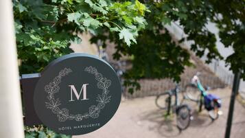 A sign for Hotel Marguerite with a logo and name.