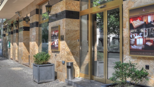 Fachada de hotel de mármol, puertas de cristal y un cartel anunciando Europa City Hotels.