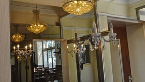 Una habitación con candelabros, un espejo y muebles de madera.