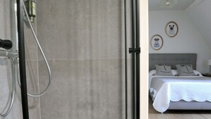 Ein modernes Badezimmer mit Duschkabine aus Glas und sichtbarer Duschbrause.