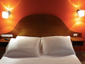 A hotel room with a large bed, two bedside tables, and wall-mounted lamps. - New Paradise (Rome)