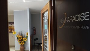 A hotel entrance with a sign reading "New Paradise Your Private Rooms in Rome". - New Paradise (Rome)