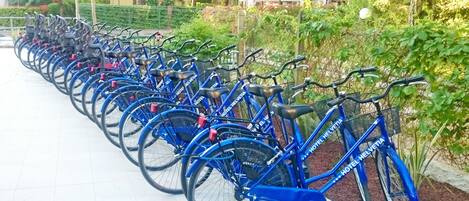 Uma fileira de bicicletas azuis estacionadas ao longo de uma calçada.