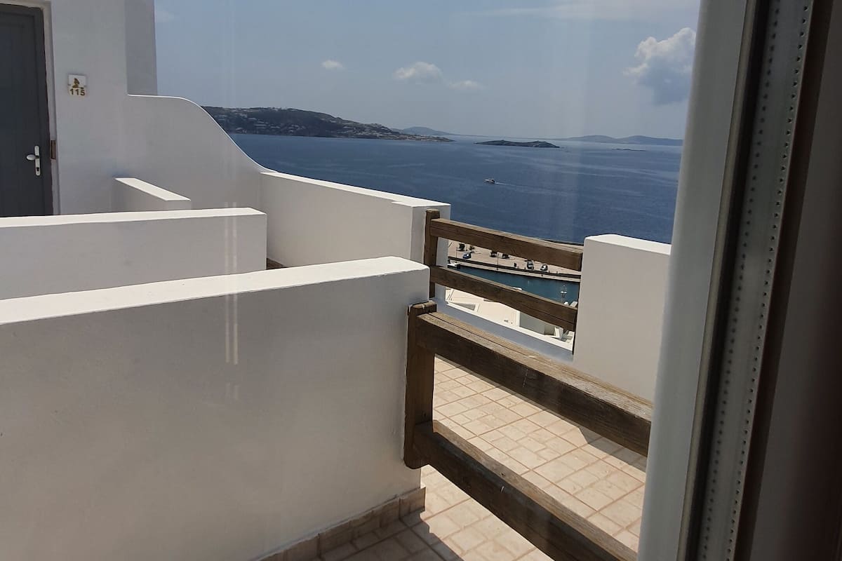 A balcony with a view of the sea and distant islands.