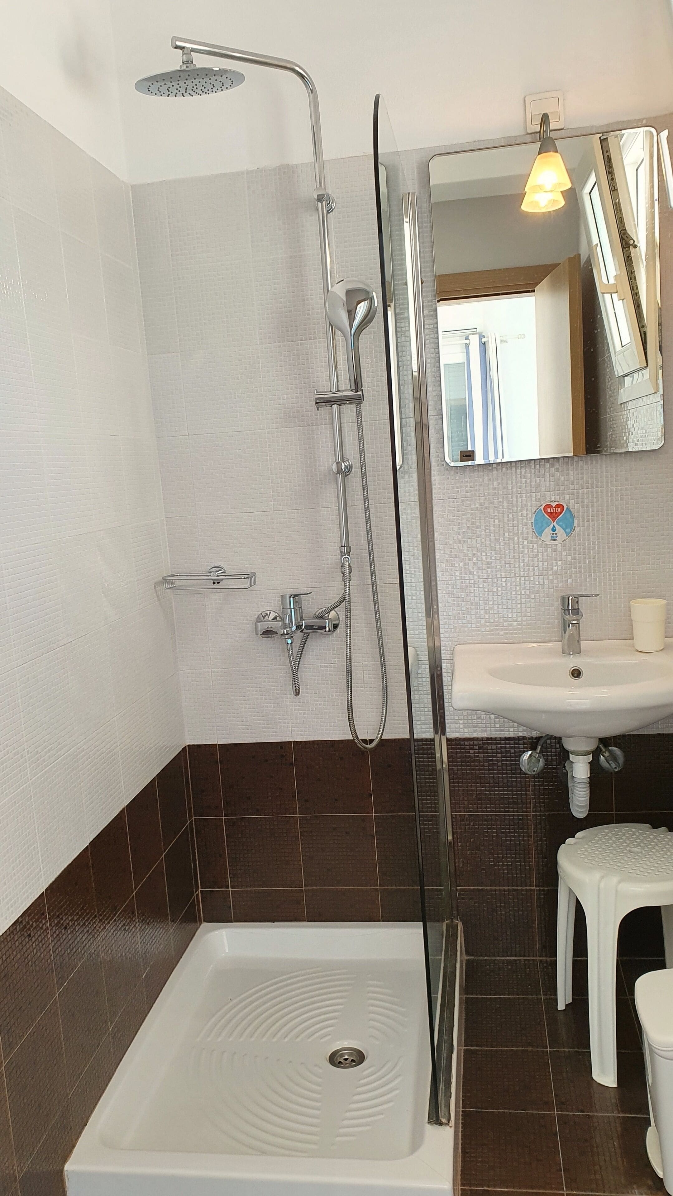 A bathroom with a shower, sink, and toilet.
