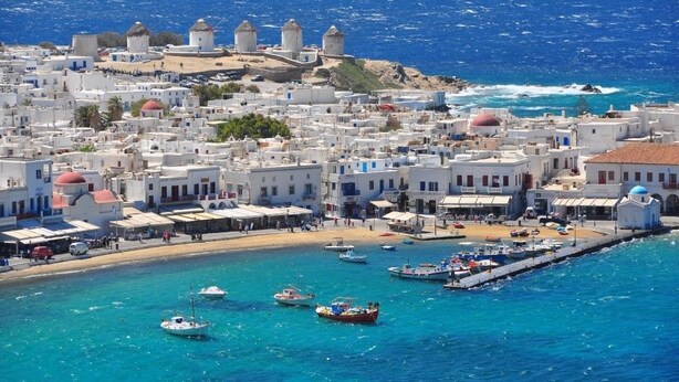 A coastal town with white buildings, a harbor with boats, and a clear blue sea. - Gorgona Hotel (Mykonos)