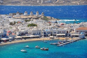 A coastal town with white buildings, a harbor with boats, and a clear blue sea. - Gorgona Hotel (Mykonos)