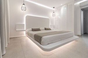 Une chambre à coucher moderne avec un lit intégré, des tables de chevet et des luminaires suspendus.