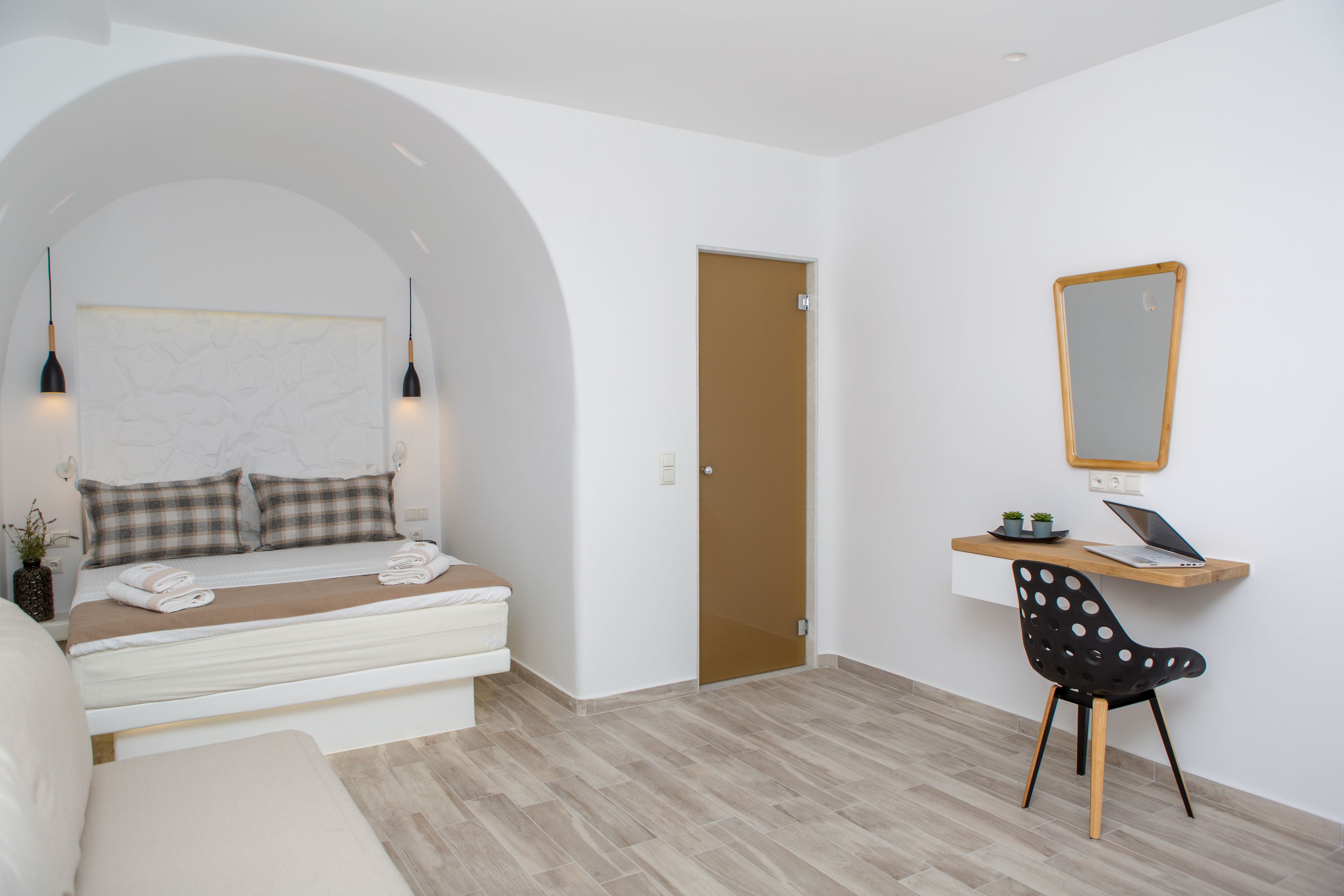 A bedroom with a bed, a desk, and a chair.