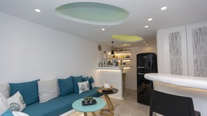 Un salon moderne avec un canapé, une petite table ronde et un coin bar.