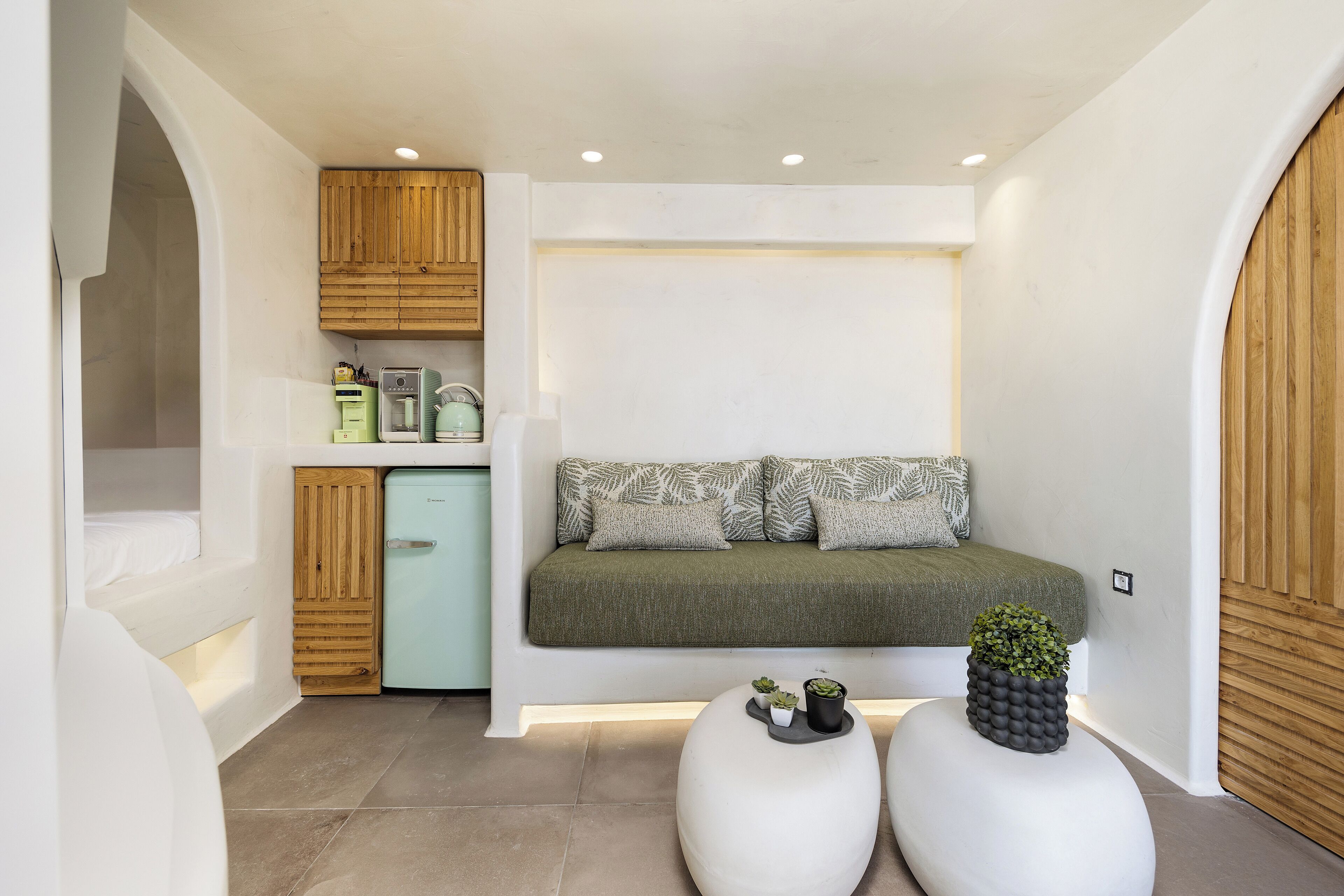 A compact room with a built-in seating area, a small kitchenette, and a compact refrigerator.