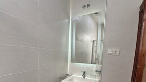 A bathroom with a white sink, mirror, and toilet. - Hostal Atocha Almudena Martin (Madrid)
