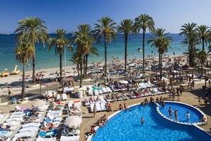 A beach resort with a large pool, sun loungers, and palm trees. - Ibiza JET Apartamentos - Adults Only (Sant Josep de sa Talaia)