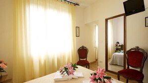 Une chambre d’hôtel avec un lit, un grand miroir et deux chaises.