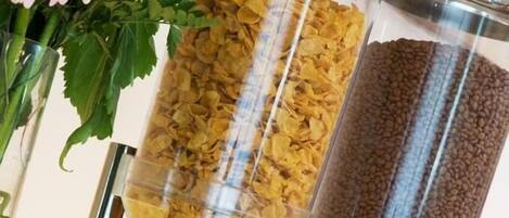 Una exhibición de cajas de cereal con un arreglo floral de fondo.