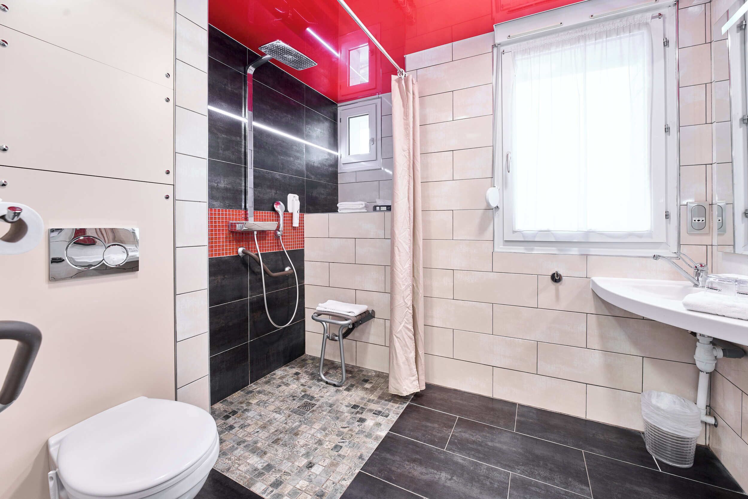 A modern bathroom with a toilet, shower, and sink.
