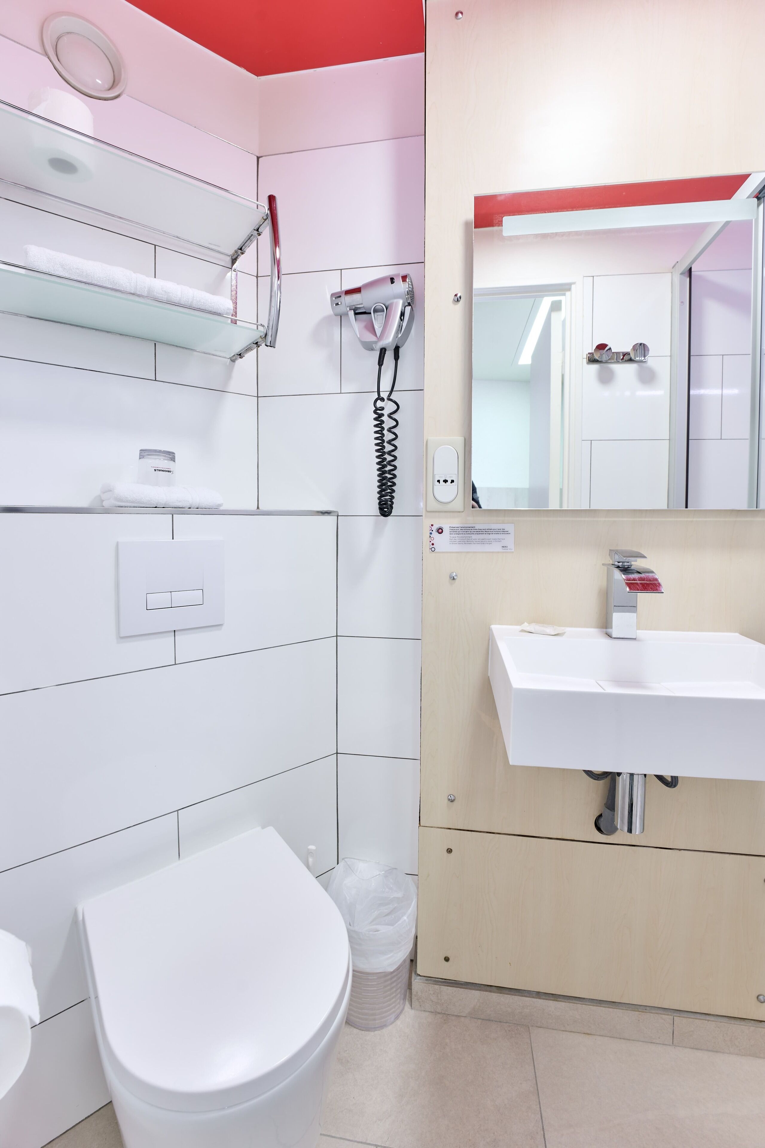 A modern bathroom with a white toilet, a sink, and a mirror.