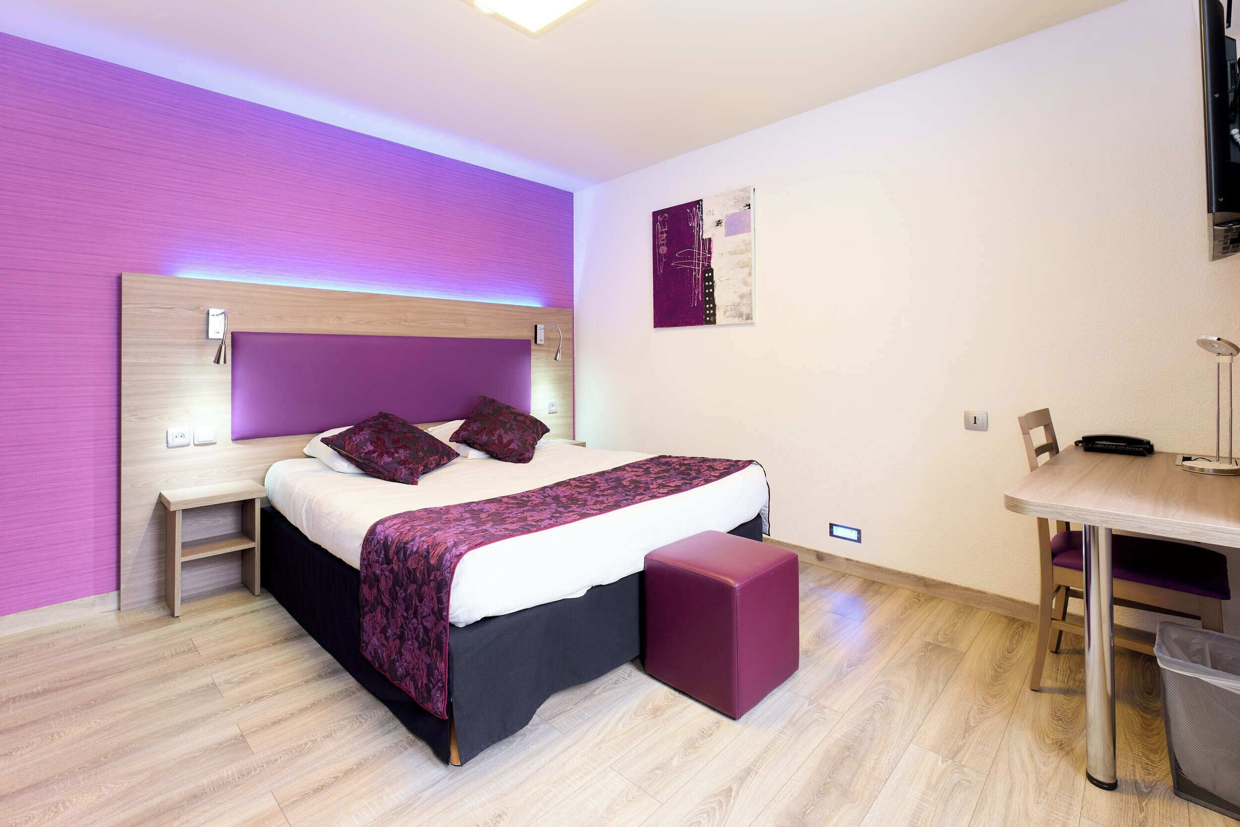 A modern bedroom with a bed, bedside tables, a desk, and a chair.