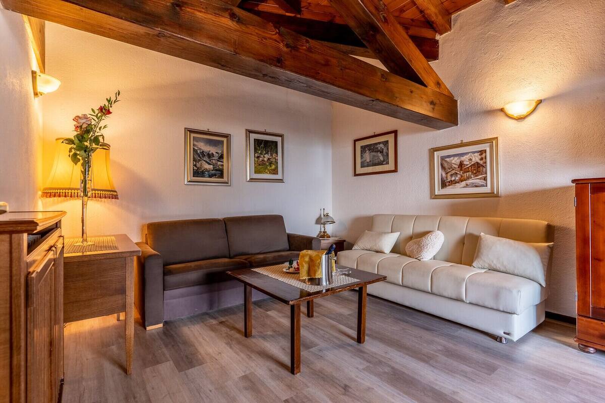 A cozy living room with a brown sofa, a beige sofa, a wooden coffee table, and a wooden cabinet.