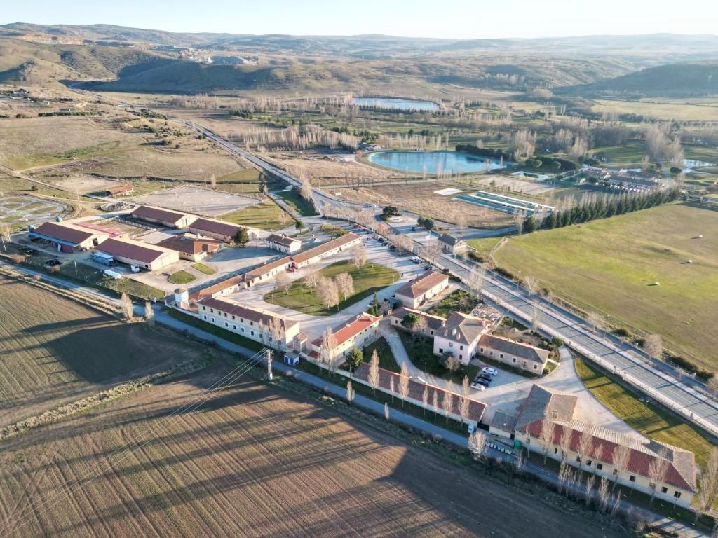 Oversigtsbillede fra luften af et landligt område med et stort bygningskompleks, veje og marker.