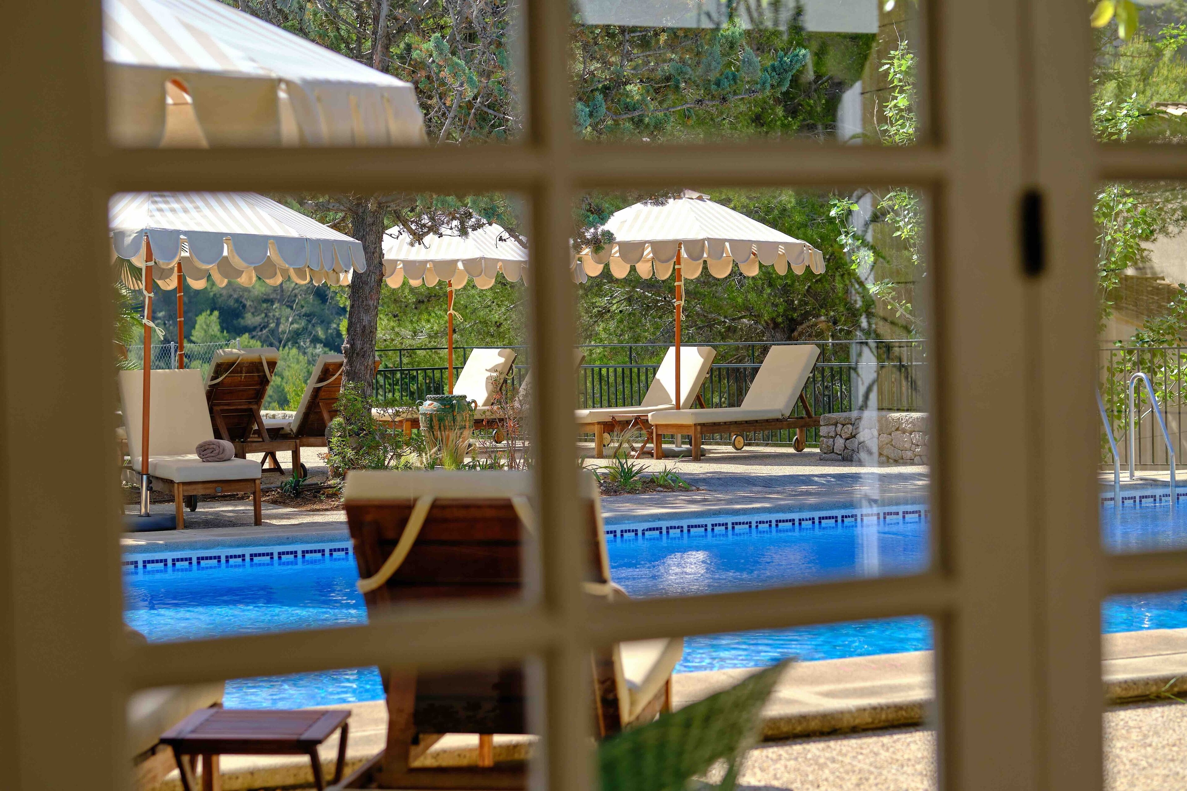 A pool area with lounge chairs and umbrellas.